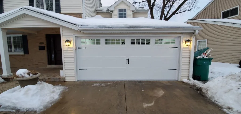 Exterior front view of a suburban house featuring a white carriage-style double door with windows, demonstrating a Standard Garage Door Panel Height.